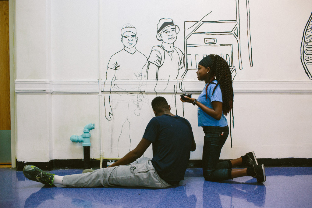 Collegiate freshman Lola, 14, and junior Dante Tyson, 16, paint the outline of the new school mural. (CREDIT: Cassandra Giraldo)